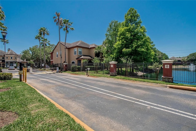 2220 Chianti Pl Unit 8-0828, Palm Harbor, FL 34683 - view of asphalt street featuring curbs, a gated entry, a residential view, and street lighting