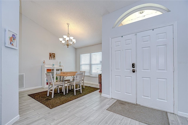 2020 Elk Spring Dr, Brandon, FL 33511 - entryway featuring a chandelier, baseboards, light wood finished floors, vaulted ceiling, and a textured ceiling