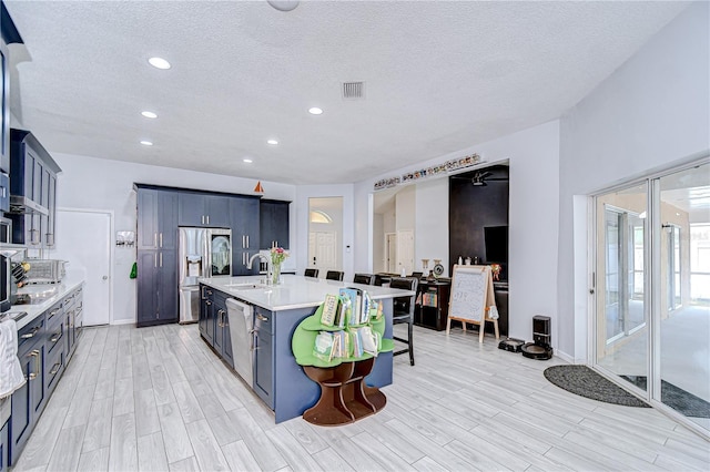 2020 Elk Spring Dr, Brandon, FL 33511 - kitchen with stainless steel fridge, light countertops, a sink, light wood-type flooring, and a textured ceiling