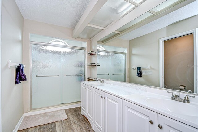 2020 Elk Spring Dr, Brandon, FL 33511 - full bathroom featuring a stall shower, wood finished floors, double vanity, beamed ceiling, and a textured ceiling
