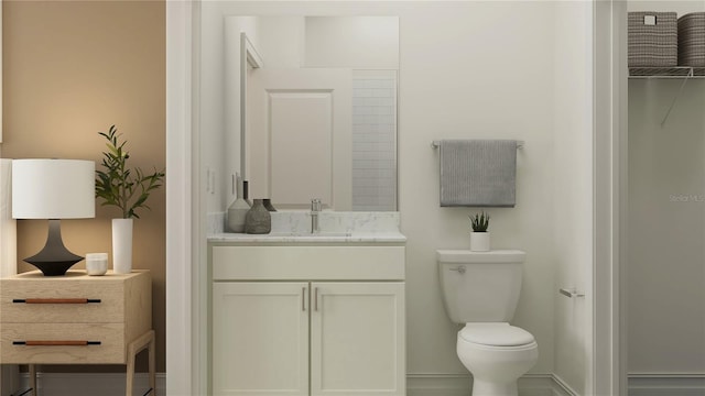bathroom with toilet, vanity, and baseboards