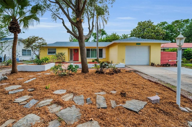 2485 Indigo Dr, Clearwater, FL 33763 - ranch-style house with stucco siding, an attached garage, concrete driveway, and fence