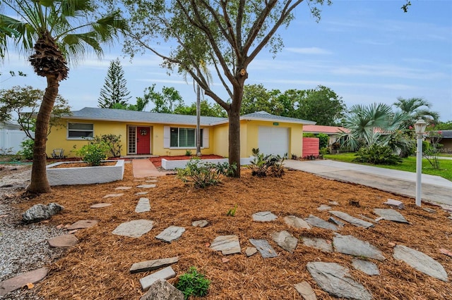 2485 Indigo Dr, Clearwater, FL 33763 - ranch-style house featuring stucco siding, an attached garage, concrete driveway, and fence