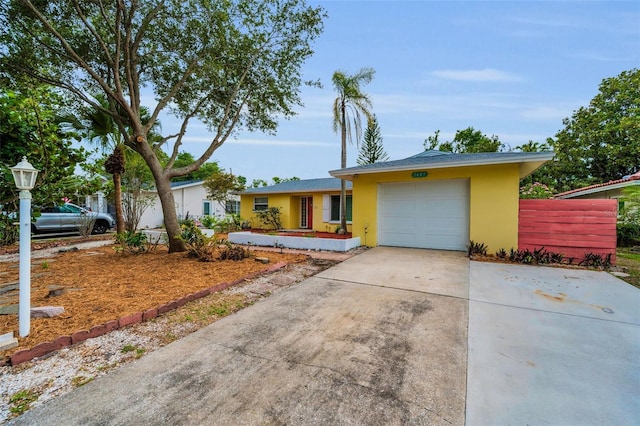 2485 Indigo Dr, Clearwater, FL 33763 - ranch-style home featuring stucco siding, an attached garage, and concrete driveway
