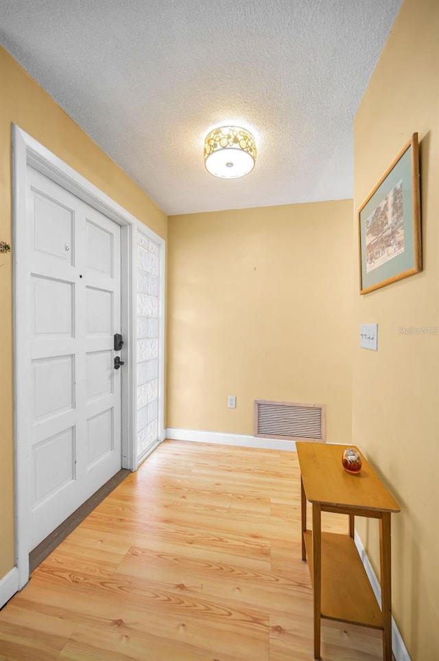 2485 Indigo Dr, Clearwater, FL 33763 - foyer entrance featuring baseboards, wood finished floors, and a textured ceiling