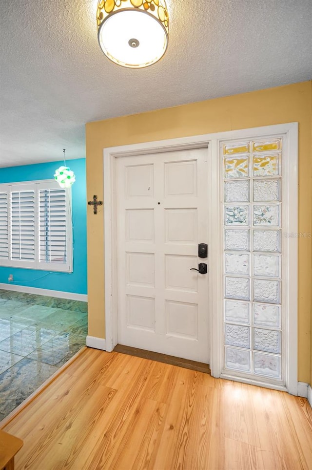 2485 Indigo Dr, Clearwater, FL 33763 - entryway with light wood-type flooring, baseboards, and a textured ceiling