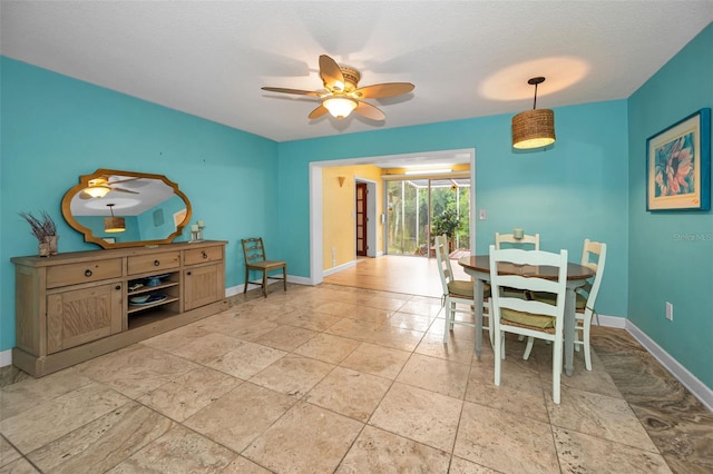 2485 Indigo Dr, Clearwater, FL 33763 - dining area featuring baseboards, a ceiling fan, and stone tile floors