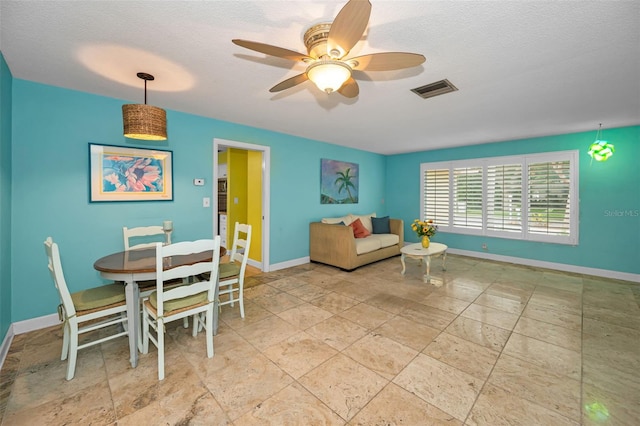 2485 Indigo Dr, Clearwater, FL 33763 - living area with stone tile floors, ceiling fan, baseboards, and a textured ceiling