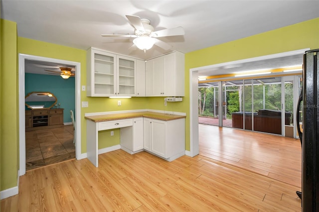2485 Indigo Dr, Clearwater, FL 33763 - kitchen featuring freestanding refrigerator, white cabinets, ceiling fan, glass insert cabinets, and light wood-type flooring