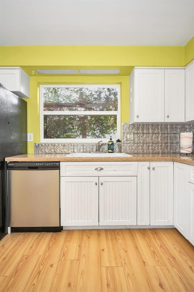 2485 Indigo Dr, Clearwater, FL 33763 - kitchen with dishwasher, a sink, white cabinets, backsplash, and healthy amount of natural light
