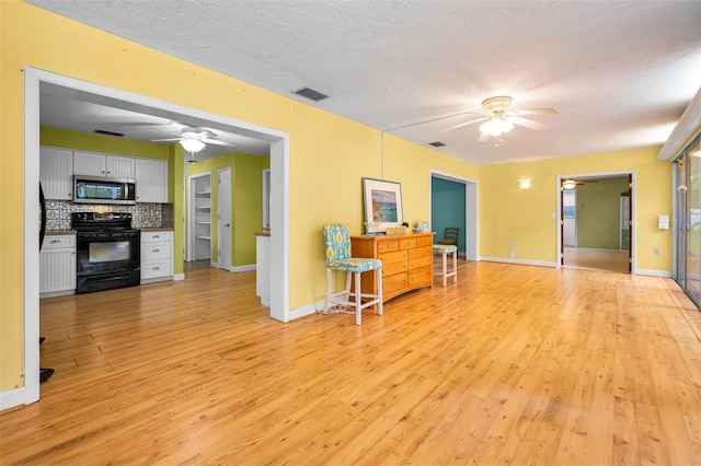 2485 Indigo Dr, Clearwater, FL 33763 - living area with a ceiling fan, light wood finished floors, baseboards, and a textured ceiling