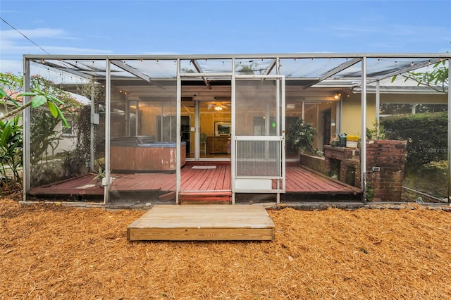 2485 Indigo Dr, Clearwater, FL 33763 - back of house featuring a hot tub, glass enclosure, and a wooden deck
