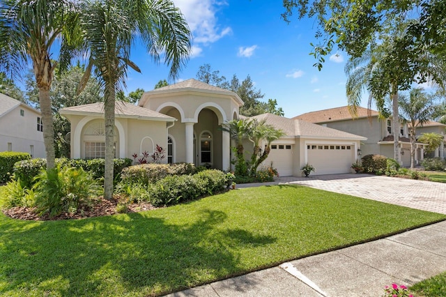 17318 Emerald Chase Dr, Tampa, FL 33647 - mediterranean / spanish-style home featuring a garage, stucco siding, a front lawn, and driveway
