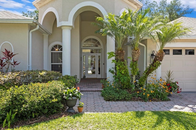 17318 Emerald Chase Dr, Tampa, FL 33647 - doorway to property featuring a garage, stucco siding, and french doors
