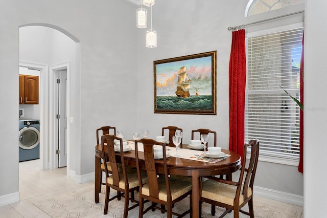 17318 Emerald Chase Dr, Tampa, FL 33647 - dining space featuring washer / dryer, arched walkways, baseboards, and light tile patterned floors