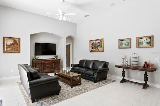 17318 Emerald Chase Dr, Tampa, FL 33647 - living area featuring arched walkways, a ceiling fan, light tile patterned flooring, baseboards, and high vaulted ceiling