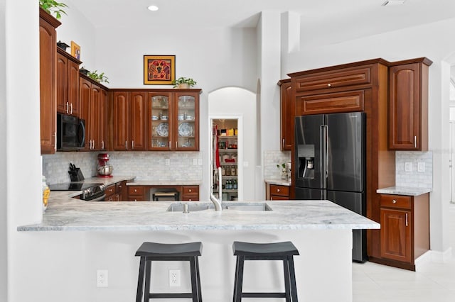 17318 Emerald Chase Dr, Tampa, FL 33647 - kitchen with fridge with ice dispenser, black microwave, a sink, light countertops, and a peninsula