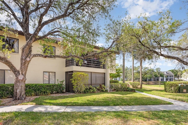 5666 Gardens Dr Unit 202, Sarasota, FL 34243 - view of front facade featuring a balcony, a front yard, and stucco siding