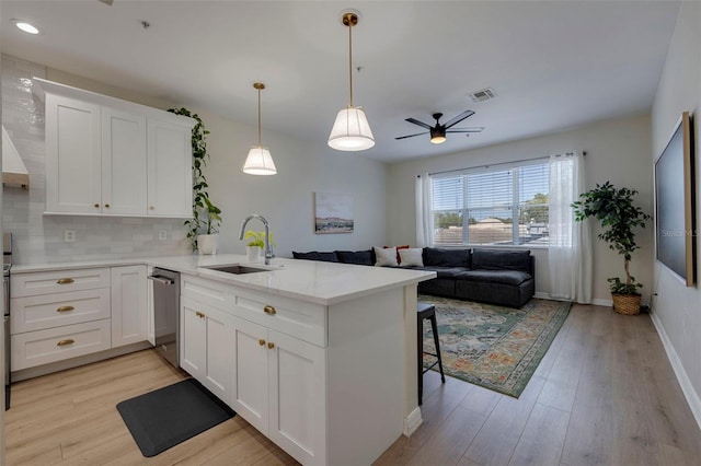 330 Lang Ct N Unit 1, Saint Petersburg, FL 33701 - kitchen featuring a sink, a peninsula, stainless steel dishwasher, a ceiling fan, and light wood-style floors