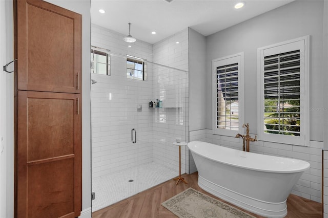 12705 Green Heron Way, Odessa, FL 33556 - bathroom with a stall shower, a soaking tub, wood finished floors, recessed lighting, and tile walls