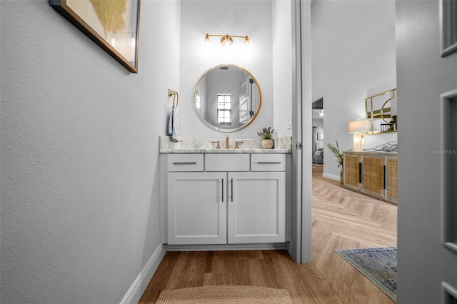 12705 Green Heron Way, Odessa, FL 33556 - bathroom featuring vanity, a towering ceiling, baseboards, and wood finished floors