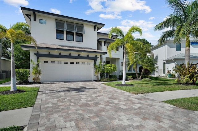 12705 Green Heron Way, Odessa, FL 33556 - view of front of house with stucco siding, a garage, decorative driveway, a front lawn, and central AC