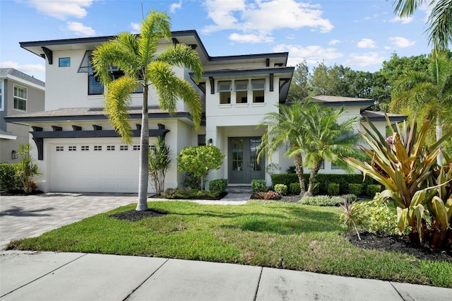 12705 Green Heron Way, Odessa, FL 33556 - view of front of house featuring french doors, stucco siding, a garage, decorative driveway, and a front yard
