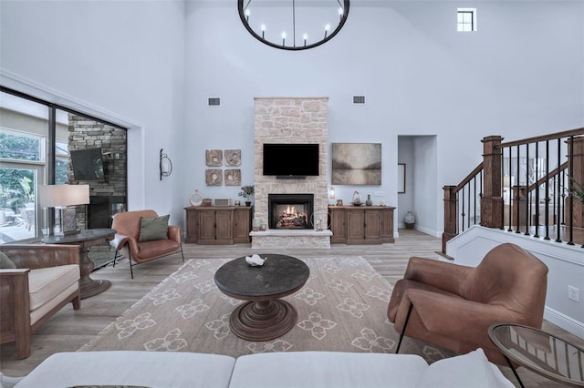 12705 Green Heron Way, Odessa, FL 33556 - living area with a stone fireplace, a towering ceiling, light wood finished floors, and a chandelier