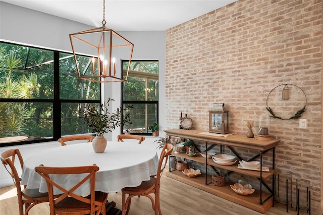 12705 Green Heron Way, Odessa, FL 33556 - dining room featuring wood finished floors, a chandelier, and brick wall