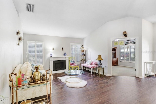 living area with lofted ceiling, wood finished floors, a fireplace, and baseboards