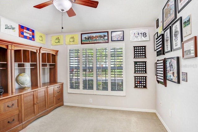 unfurnished room featuring a ceiling fan, light colored carpet, and baseboards