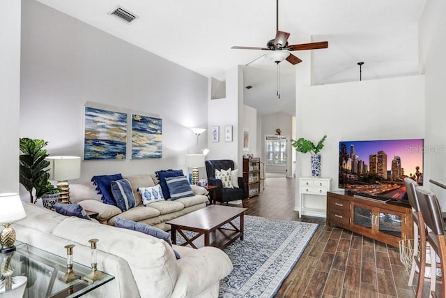 living area with ceiling fan, dark wood-style flooring, and high vaulted ceiling