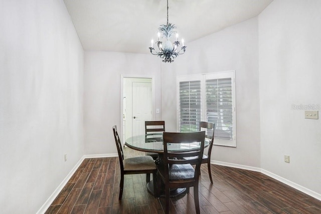 dining area featuring dark wood finished floors, a chandelier, and baseboards