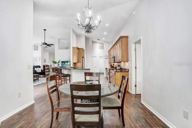 dining area with high vaulted ceiling, baseboards, dark wood-style flooring, ceiling fan, and a chandelier