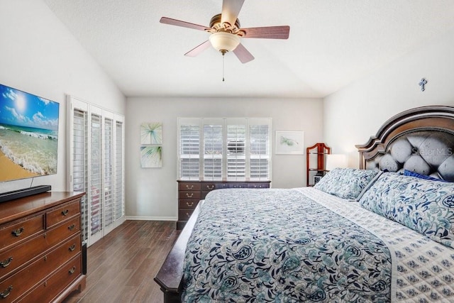 bedroom featuring dark wood-style flooring, baseboards, lofted ceiling, and ceiling fan