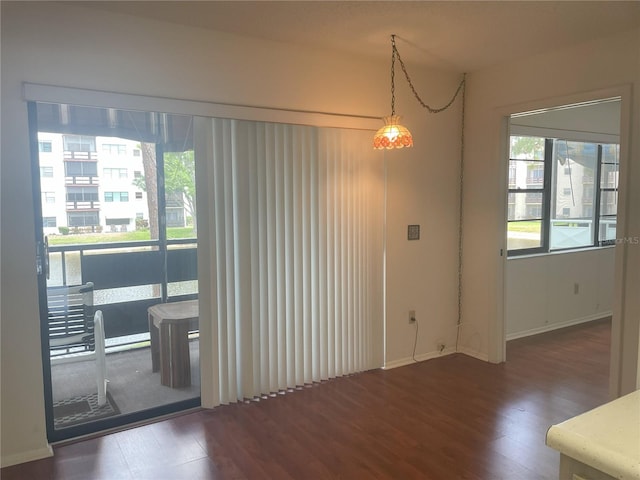unfurnished dining area with wood finished floors and baseboards