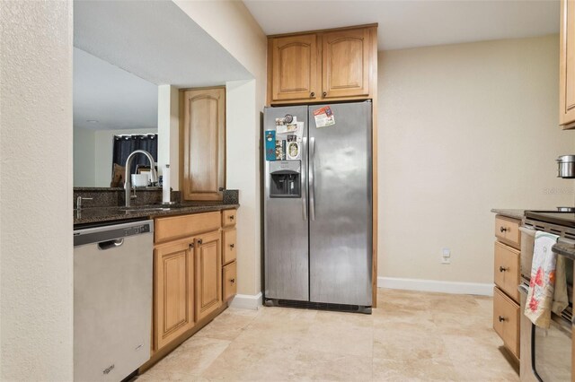 2814 W Humphrey St, Tampa, FL 33614 - kitchen with stainless steel appliances, dark stone countertops, baseboards, and a sink