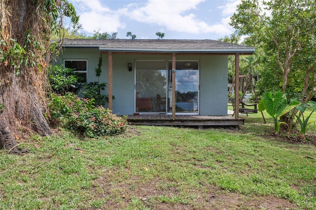 2814 W Humphrey St, Tampa, FL 33614 - rear view of property with stucco siding, a lawn, and a deck