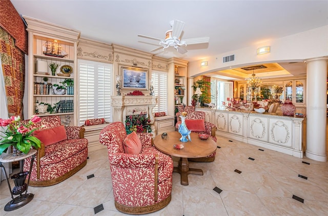 sitting room with ornate columns, light tile patterned floors, a chandelier, ceiling fan, and ornamental molding