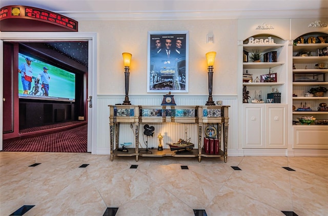 living area with ornamental molding and wainscoting