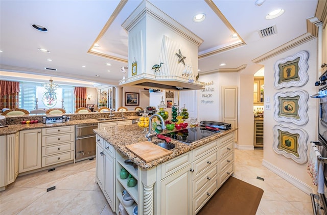 kitchen with a raised ceiling, black electric cooktop, a sink, light tile patterned floors, and cream cabinets