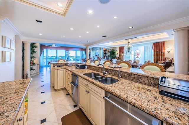 kitchen featuring ornate columns, cream cabinets, crown molding, stainless steel dishwasher, and a sink