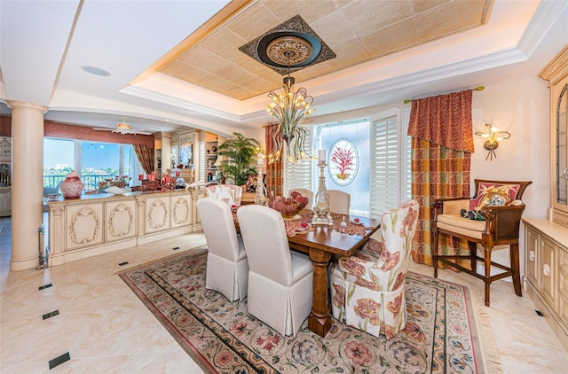 dining space featuring a raised ceiling, decorative columns, and a ceiling fan
