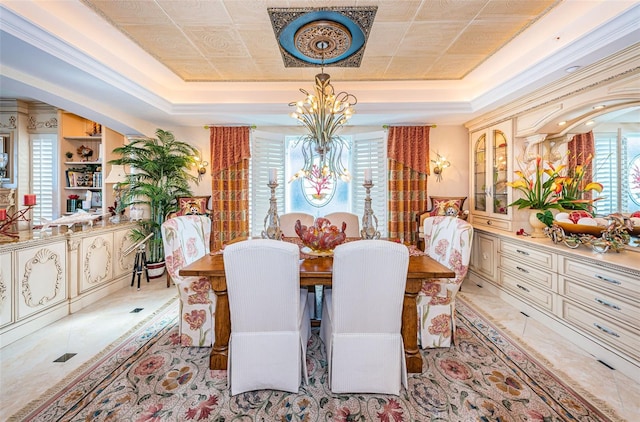 dining room featuring a raised ceiling, a chandelier, and light tile patterned flooring