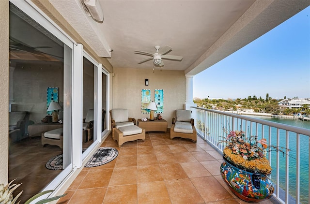 balcony with a water view and a ceiling fan