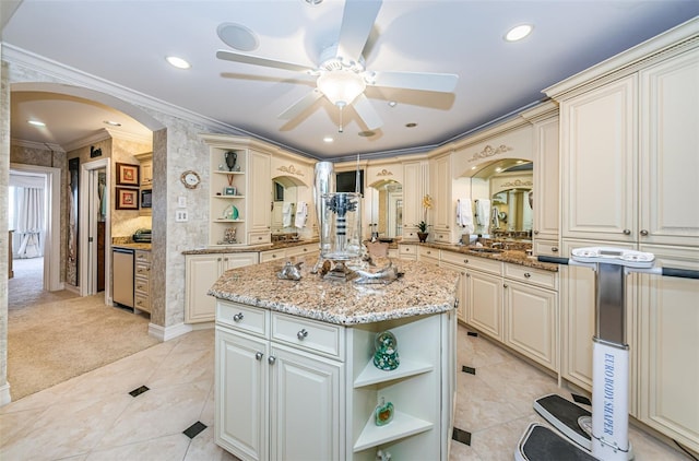 kitchen featuring open shelves, arched walkways, ornamental molding, ceiling fan, and cream cabinetry