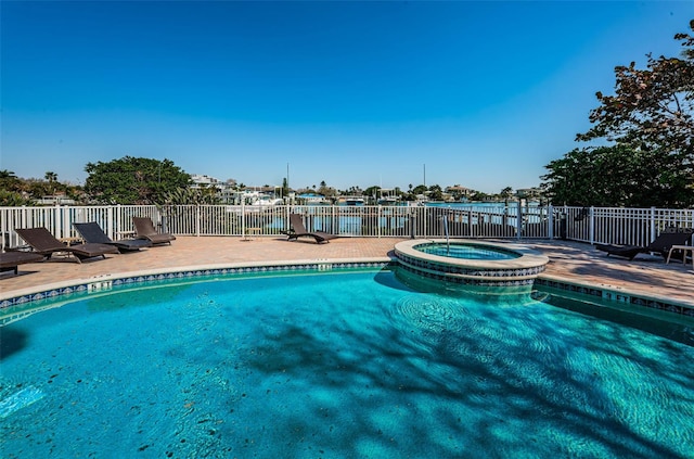 view of pool featuring fence, a pool with connected hot tub, and a patio