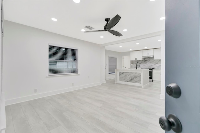 1914 E Emma St, Tampa, FL 33610 - unfurnished living room with a ceiling fan, light wood-style flooring, a sink, recessed lighting, and baseboards
