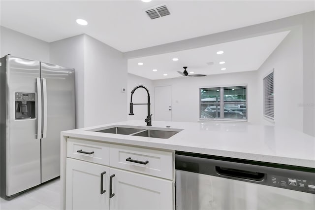 1914 E Emma St, Tampa, FL 33610 - kitchen with stainless steel appliances, a sink, a ceiling fan, white cabinets, and recessed lighting