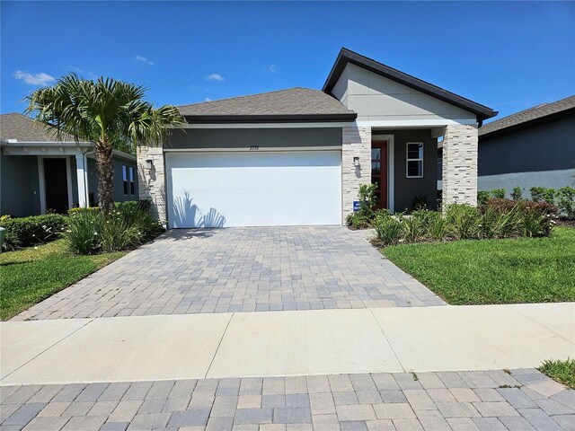 3776 Maxwell Park Dr, Sun City Center, FL 33573 - single story home with an attached garage, decorative driveway, and stone siding
